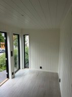 Innvendig rom i annekset med glassdør og vinduer.